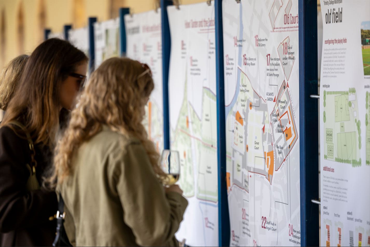 Alumnae viewing the Trinity 2046 exhibition display boards in Nevile's Court, August 2023.